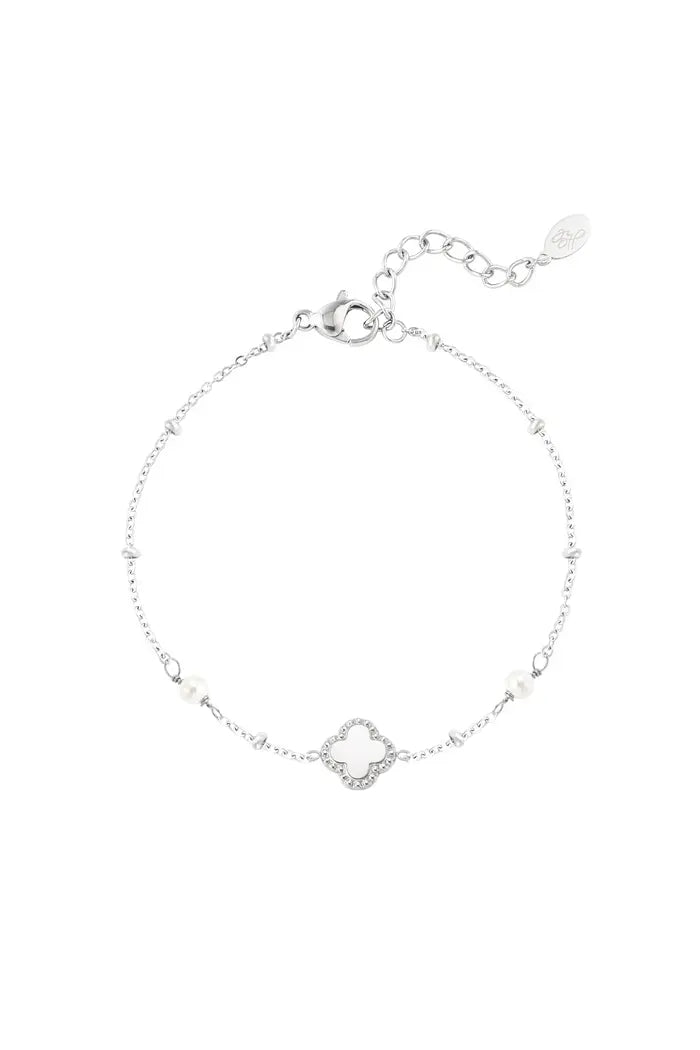 Zilverkleurige armband met klaverbedel en parels, elegant en tijdloos design.