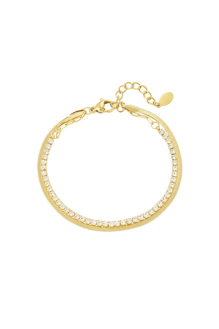 Gouden dubbele armband met sprankelende diamantjes, subtiel gestyled op een neutrale achtergrond.
