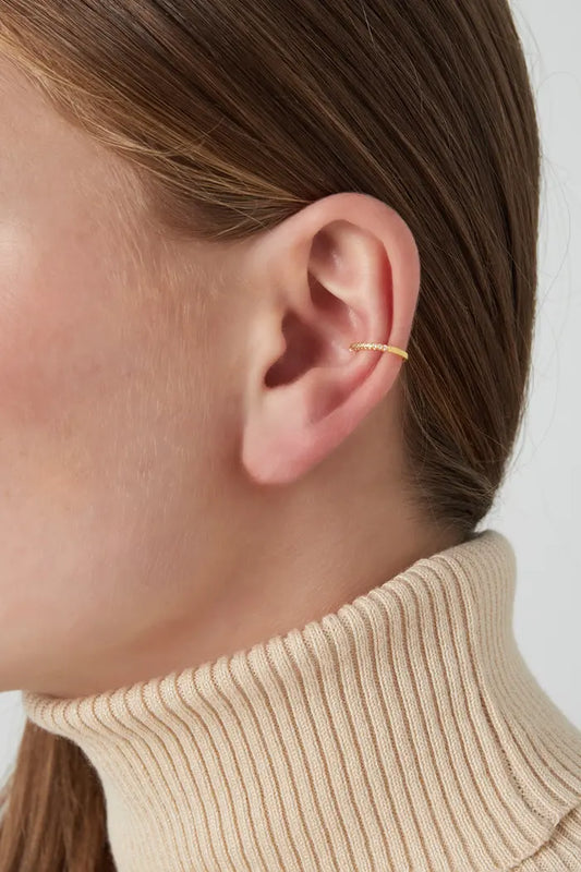Zilverkleurige earcuff 'Diamant Glow' met een verfijnd ontwerp en fonkelende details, elegant gepresenteerd.