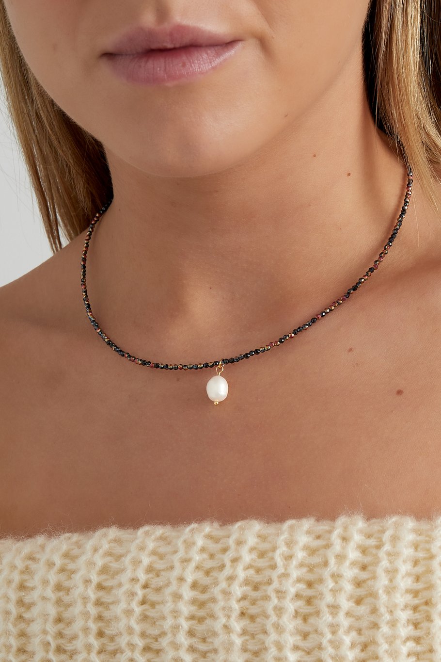 Elegante goudkleurige ketting met glanzende parel, perfect voor een chique en vrouwelijke look.